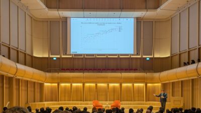 Anthropic co-founder Jack Clark speaking at a lectern