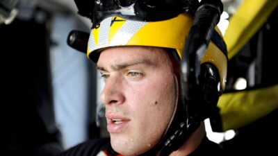 A U.S. Coast Guard rescue swimmer inside an MH-60 Jayhawk helicopter during hoist training