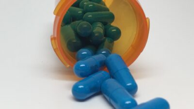 Capsules spilling from an orange prescription bottle