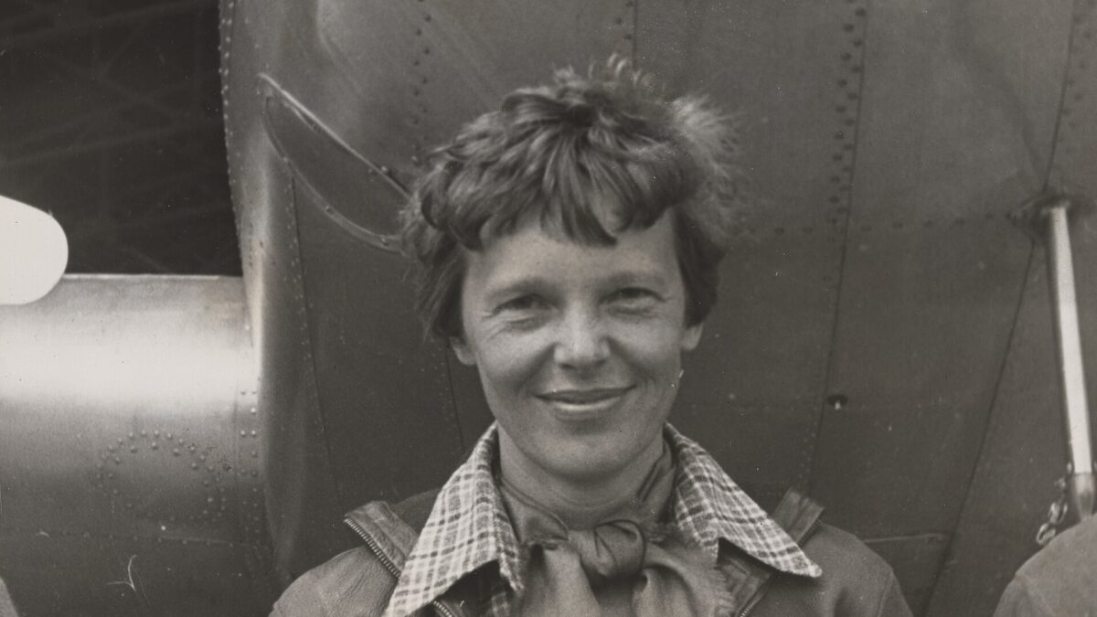 Amelia Earhart standing under the nose of her Lockheed Model 10-E Electra in 1937