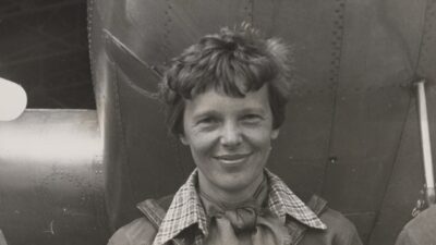 Amelia Earhart standing under the nose of her Lockheed Model 10-E Electra in 1937