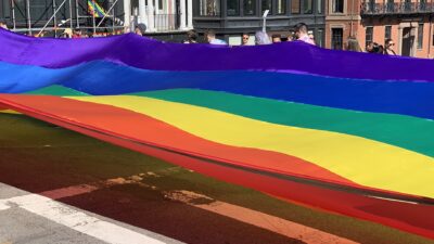A large rainbow flag carried during a Pride parade in Boston