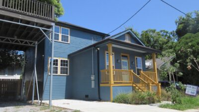 A newly built two-story house with a For Sale sign in the front yard