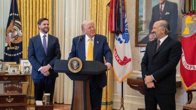 President Donald Trump speaks at a lectern in the Oval Office as Vice President JD Vance looks on (file photo)