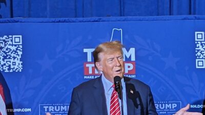 Donald Trump speaks at a campaign podium in front of a blue Team Trump backdrop (file photo)