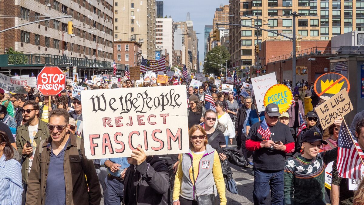 Demonstrators march with signs at an October 2025 No Kings rally in New York City