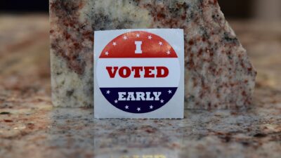 An “I Voted Early” sticker propped against a granite block