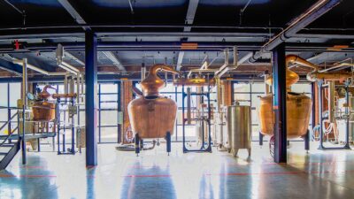 Copper pot stills and pipework inside a craft distillery