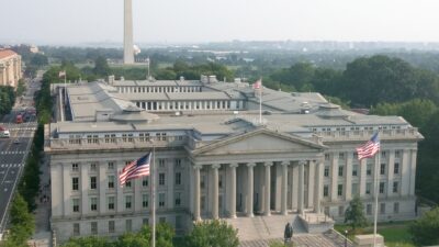 The United States Treasury Building in Washington, D.C., with the Washington Monument in the background